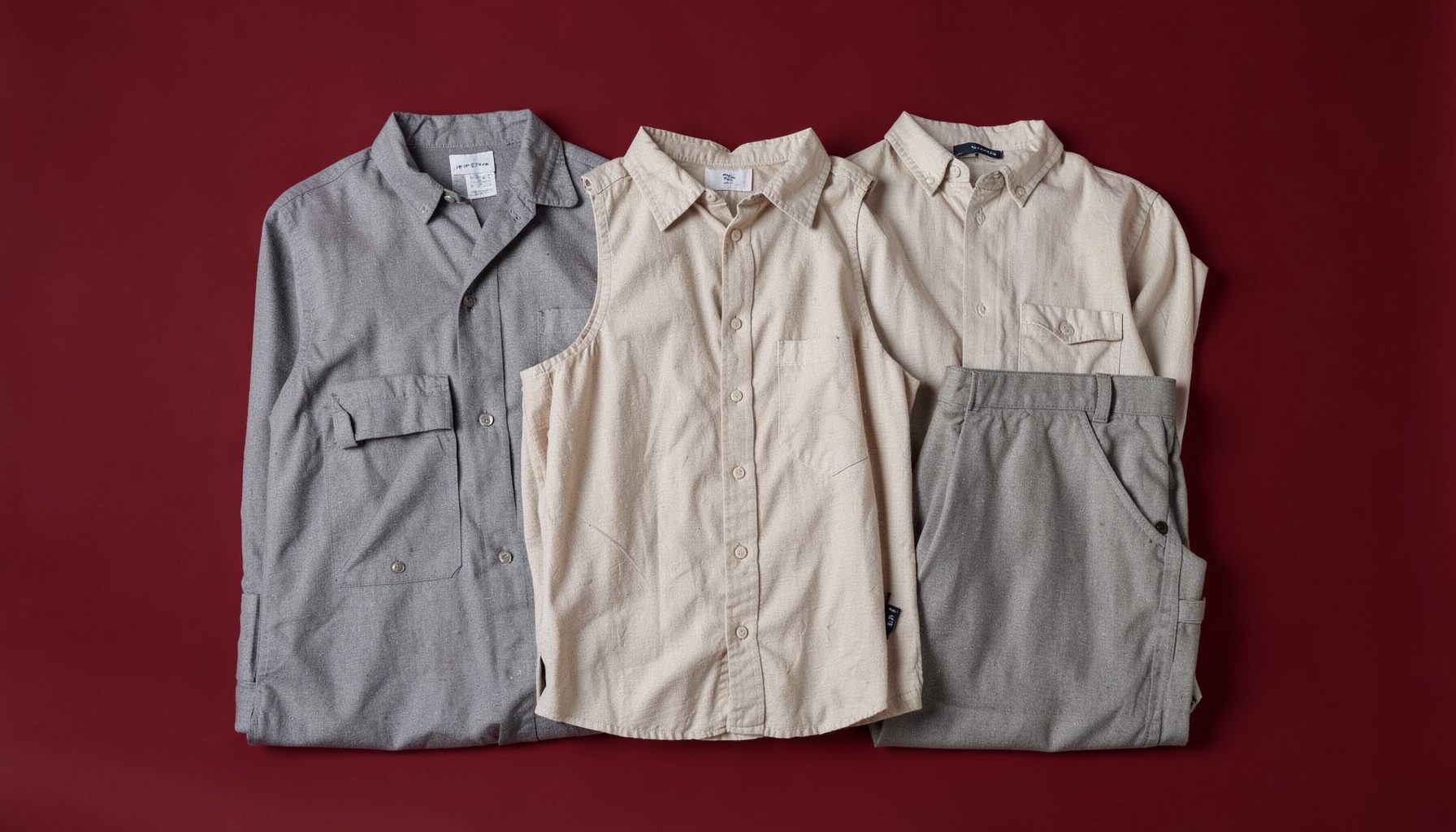 A neatly arranged collection of practical everyday clothing on a seamless backdrop, neutral earth tones, clean and timeless aesthetic